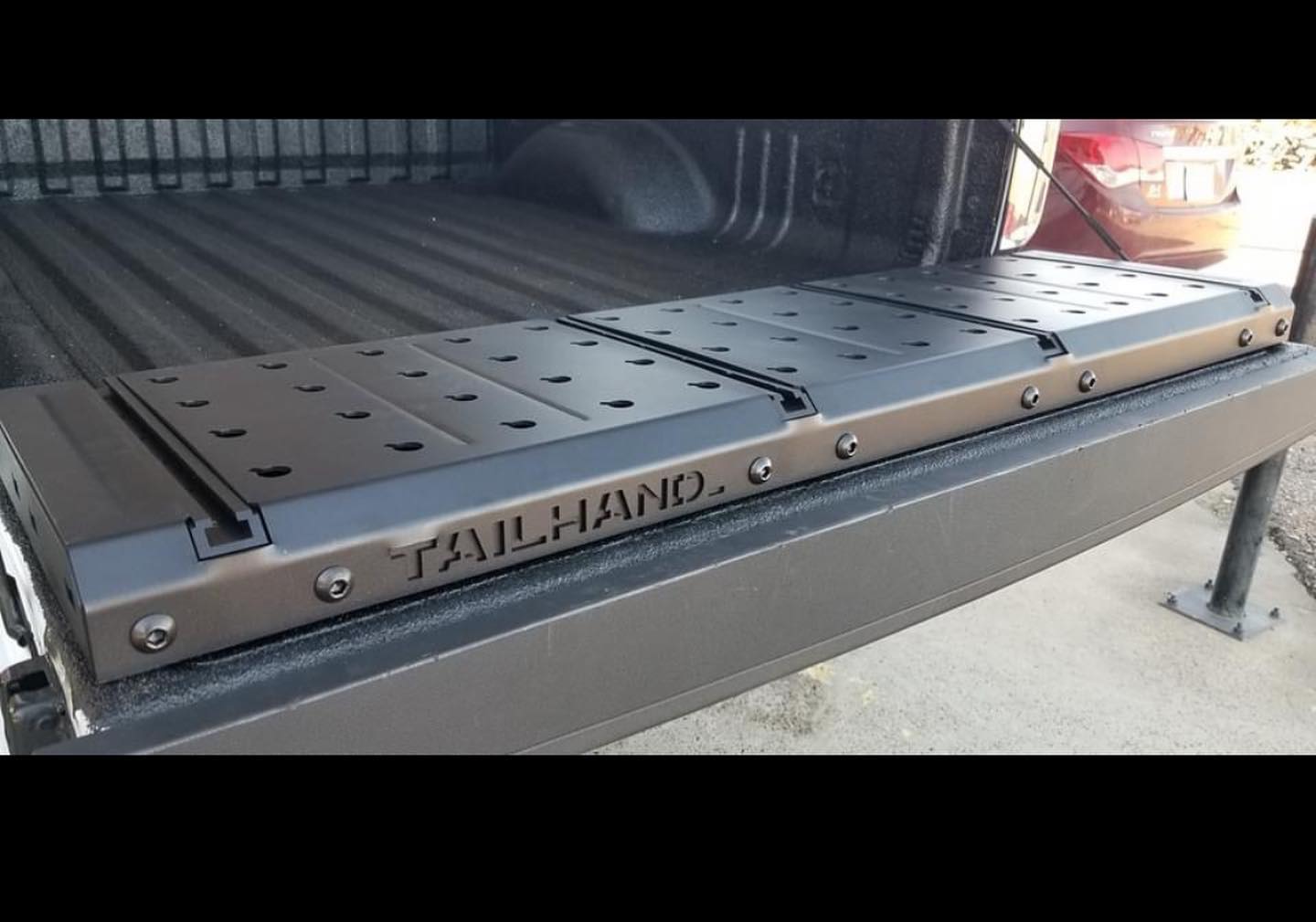 TailHand truck tailgate workstation with T-tracks and dog holes for bench dog tools.